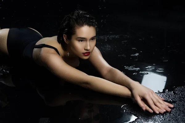 Красива азіатська мокра велика грудьми дівчина в чорному купальнику лежала — стокове фото