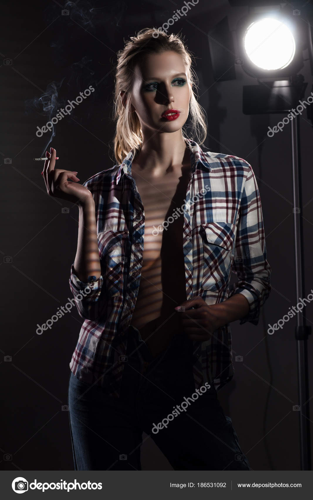 Beautiful smoking slender blonde big breasts girl without a bra Stock Photo  by ©alextorb 186531092