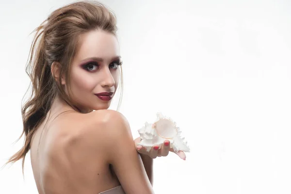 Beautiful naked shoulders girl holds a seashell in her hand. Hea — Stock Photo, Image