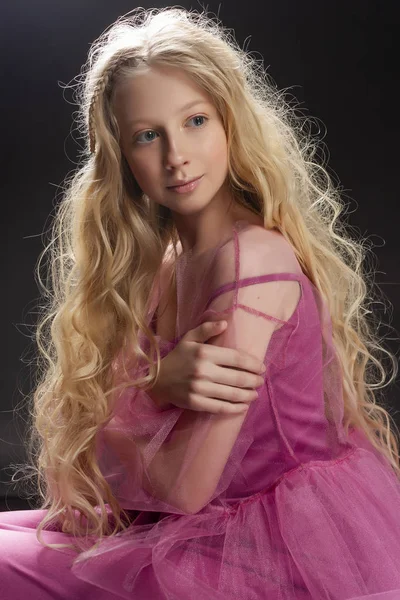 Beautiful curly blonde teenager child girl wearing a pink air dr — Stock Photo, Image