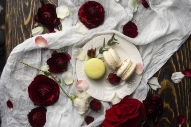 Gül bloss tarafından çevrili bir plaka üzerinde yalan üç bademli kurabiye pasta