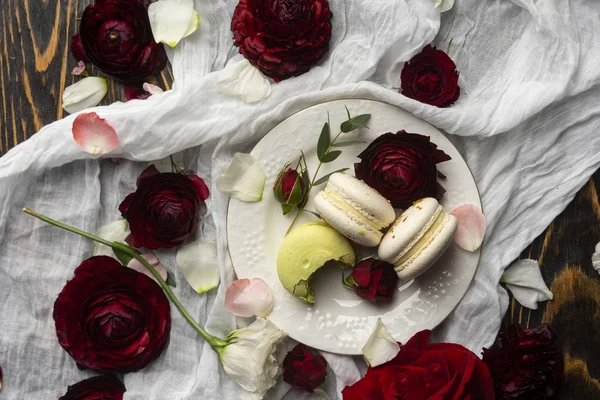 Drie bitterkoekjes gebak liggend op een plaat omgeven door roos bloss — Stockfoto