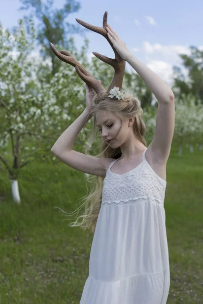 Gyönyörű tini szőke lány visel fehér ruha, szarvas szarv o — Stock Fotó