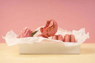 Birkaç pembe bademli kurabiye kek biri ısırılan ben yerleştirilir