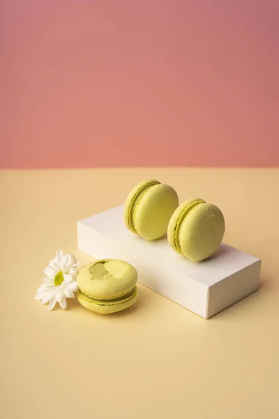 Three green pistachio macaroons cakes on a white gift box with b — Stock Photo, Image