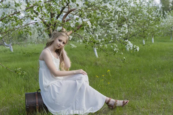 Adolescente linda menina loira vestindo vestido branco com chifres de veado o — Fotografia de Stock