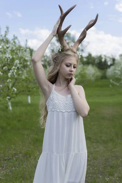 Gyönyörű tini szőke lány visel fehér ruha, szarvas szarv o — Stock Fotó