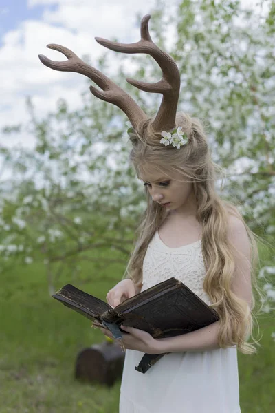 Adolescente hermosa chica rubia con vestido blanco con cuernos de ciervo o — Foto de Stock