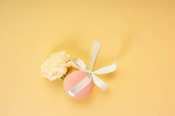 Roze macaroon taart, gebonden met een gift lint met een strik, op een yel — Stockfoto