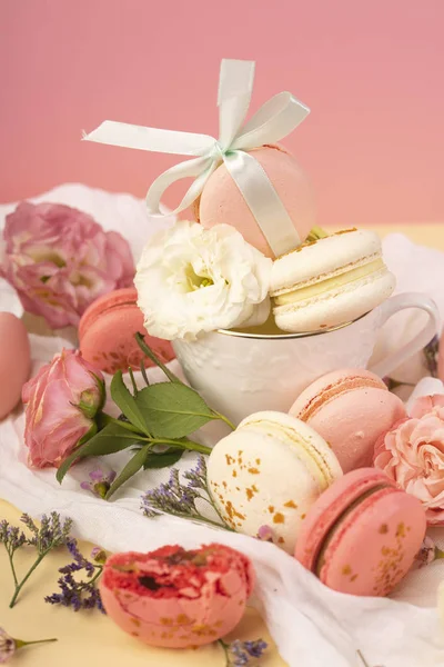 Pink and white macaroons cakes with big and small flower buds ar