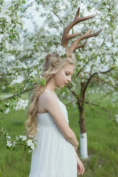 Підліток красива блондинка в білій сукні з рогами оленя — стокове фото