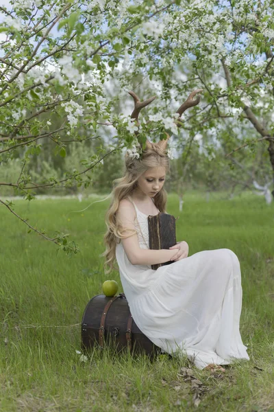 Adolescente linda menina loira vestindo vestido branco com chifres de veado o — Fotografia de Stock