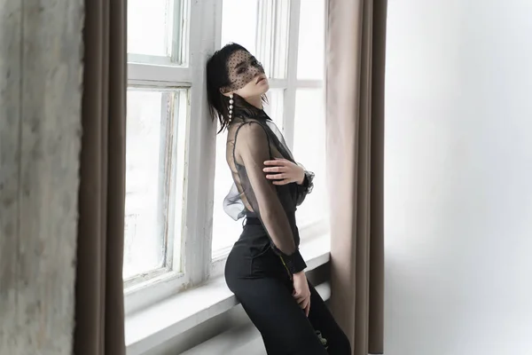 Una hermosa chica asiática con pantalones, una blusa transparente y — Foto de Stock