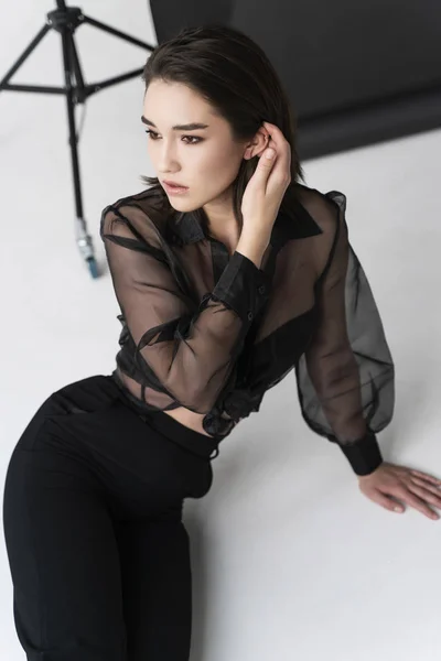 Hermosa chica asiática con pantalones, una blusa transparente y — Foto de Stock