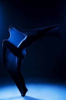 Beyaz bir beden giyen zayıf kız modern bir avangard dansı yapıyor.