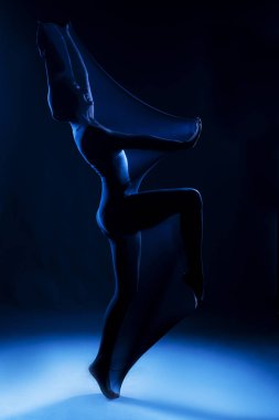 Beyaz bir beden giyen zayıf kız modern bir avangard dansı yapıyor.