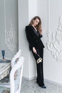 Güzel, ince, sarışın, kırmızı dudaklı, siyah pantolonlu bir kız. 