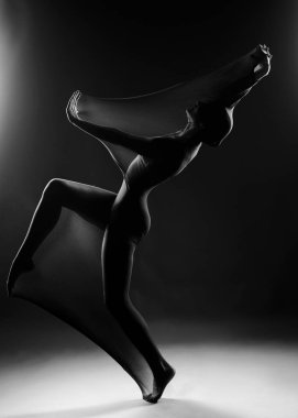 Beyaz bir beden giyen zayıf kız modern bir avangard dansı yapıyor.