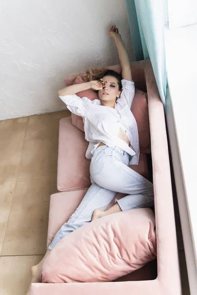 Krásná Prsatá Dívka Džínách Košili Relaxuje Pohovce Okna Módní Reklama — Stock fotografie