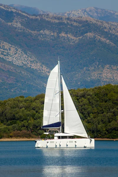 Catamarano a vela nella baia di Tivat Foto Stock