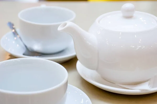 Dos tazas de té de cerámica blanca con cucharas brillantes y platillos y una t —  Fotos de Stock