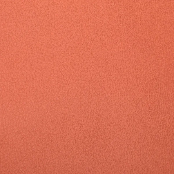 En bit av rosa-orange konstläder textur närbild — Stockfoto