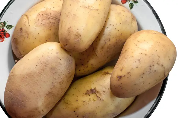 Algumas batatas cruas e não limpas jazem em uma tigela de ferro — Fotografia de Stock
