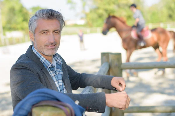 Fazendeiro com cavalo e mão de fazenda — Fotografia de Stock