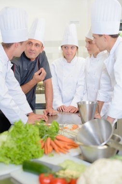 Chef talking to team of apprentices clipart