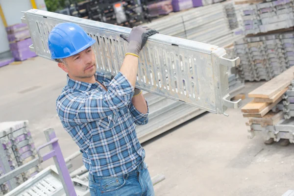 Lavoratore cantiere che trasporta un materiale — Foto Stock