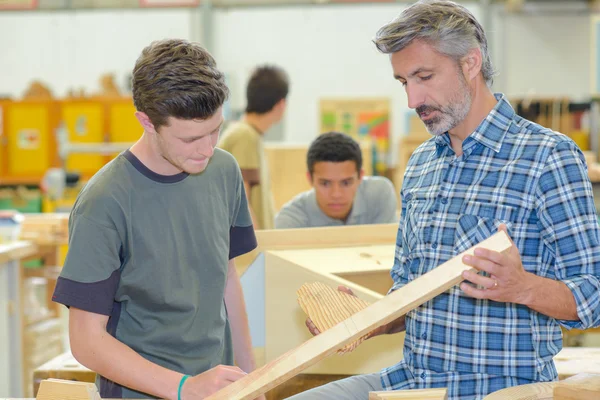 Carpenter talking to apprentice — Stock Photo, Image