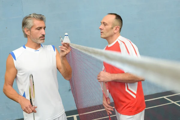 Badminton jogadores segurando um shuttlecock — Fotografia de Stock