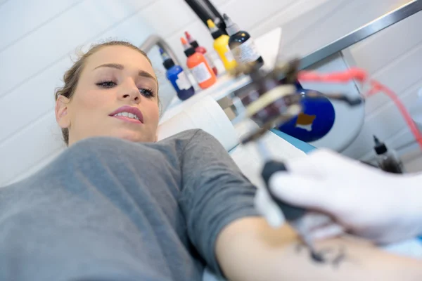 Женщина надевает татуировку — стоковое фото