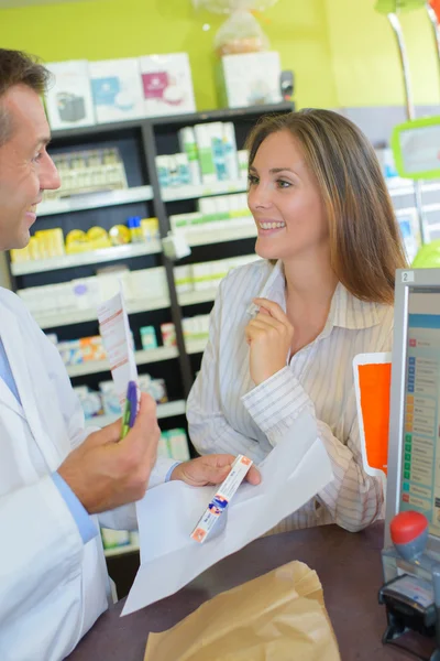 Жінка купує ліки в аптеці — стокове фото