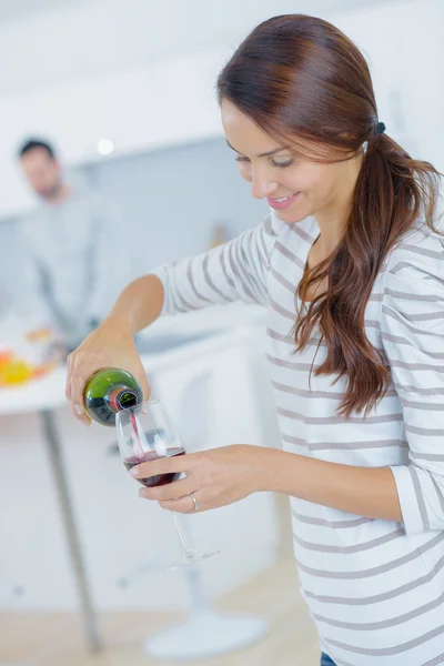 Vrouw gieten van rode wijn in een glas — Stockfoto