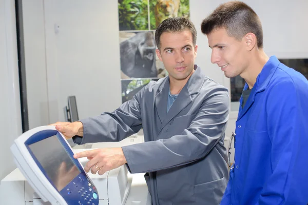 Man showing electronic control panel to apprentice — Stock Photo, Image