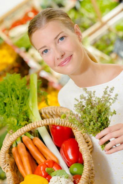 Lady adding herbs to purchases — Stock Photo, Image