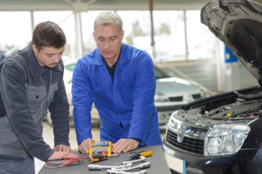student with instructor repairing a car during apprenticeship clipart
