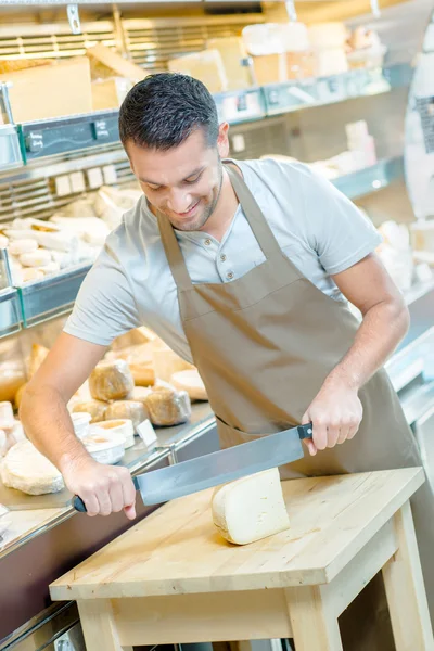 Trabajador local de delicatessen rebanando queso —  Fotos de Stock