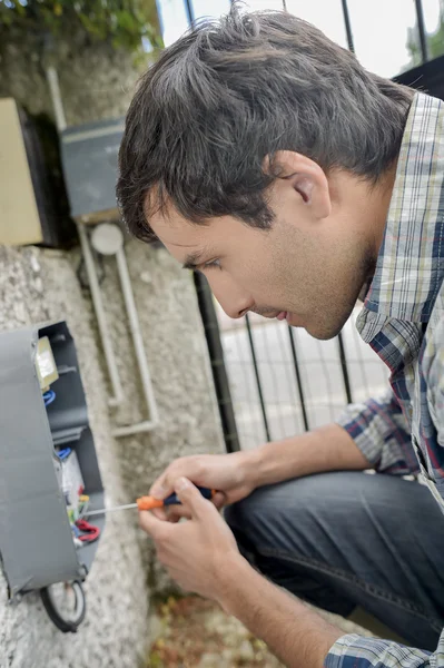 Eletricista reparando um sistema de intercomunicação — Fotografia de Stock