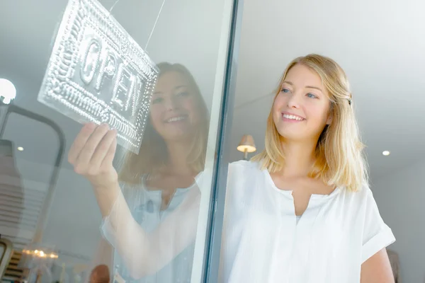 Lady håller öppen logga in shopfront — Stockfoto