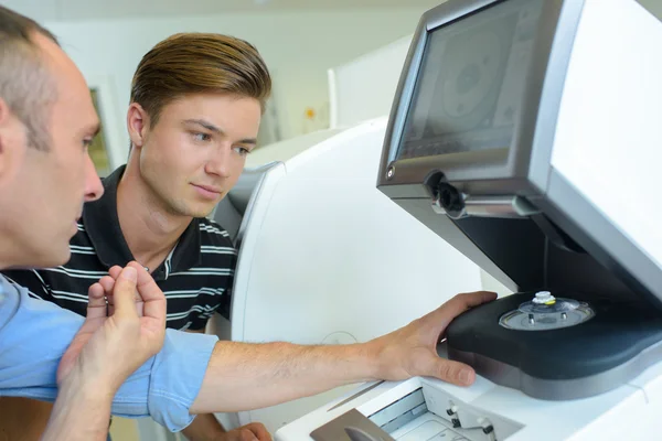 Opticien en leerling met behulp van machines — Stockfoto