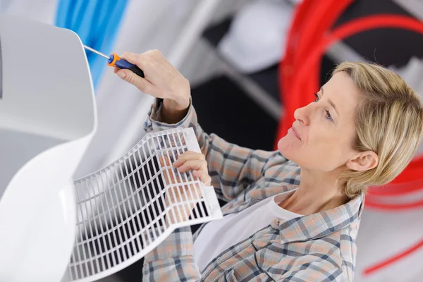 Young woman fixing air conditioner — Stock Photo, Image
