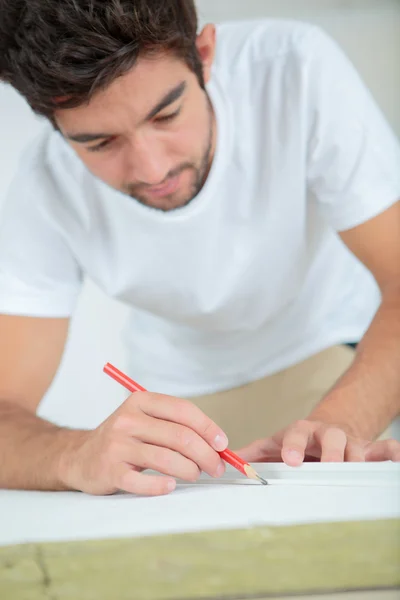 Workman marking material with pencil — Stock Photo, Image