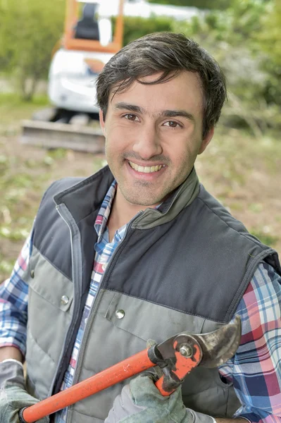 Hombre sosteniendo tijeras de podar, sonriendo — Foto de Stock