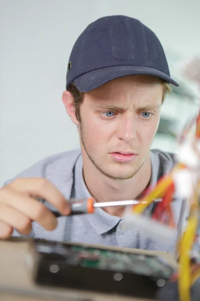 Junger Elektriker mit verblüfftem Gesichtsausdruck — Stockfoto