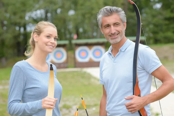 Couple holding bows and arrows — Stock Photo, Image