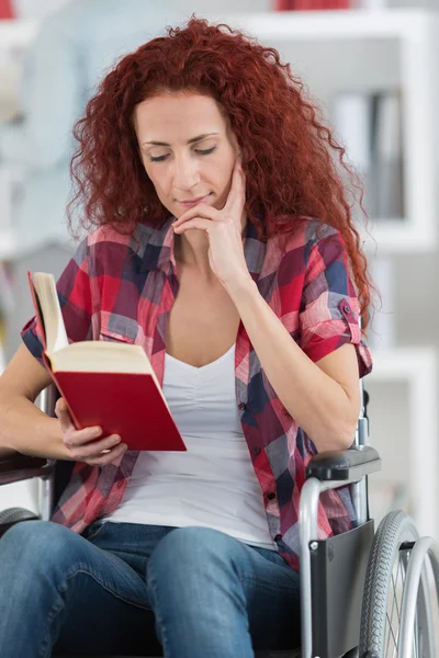 Retrato de mulher em uma cadeira de rodas segurando um livro — Fotografia de Stock