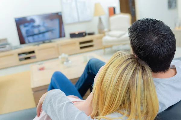 Couple watching television and affectionate Stock Image