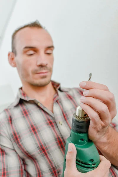 Arbeiter überprüft seinen Bohrer — Stockfoto